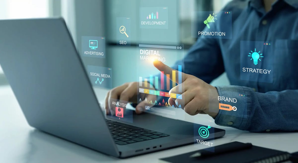 Business professional using laptop with holographic digital marketing analytics and strategy icons displayed