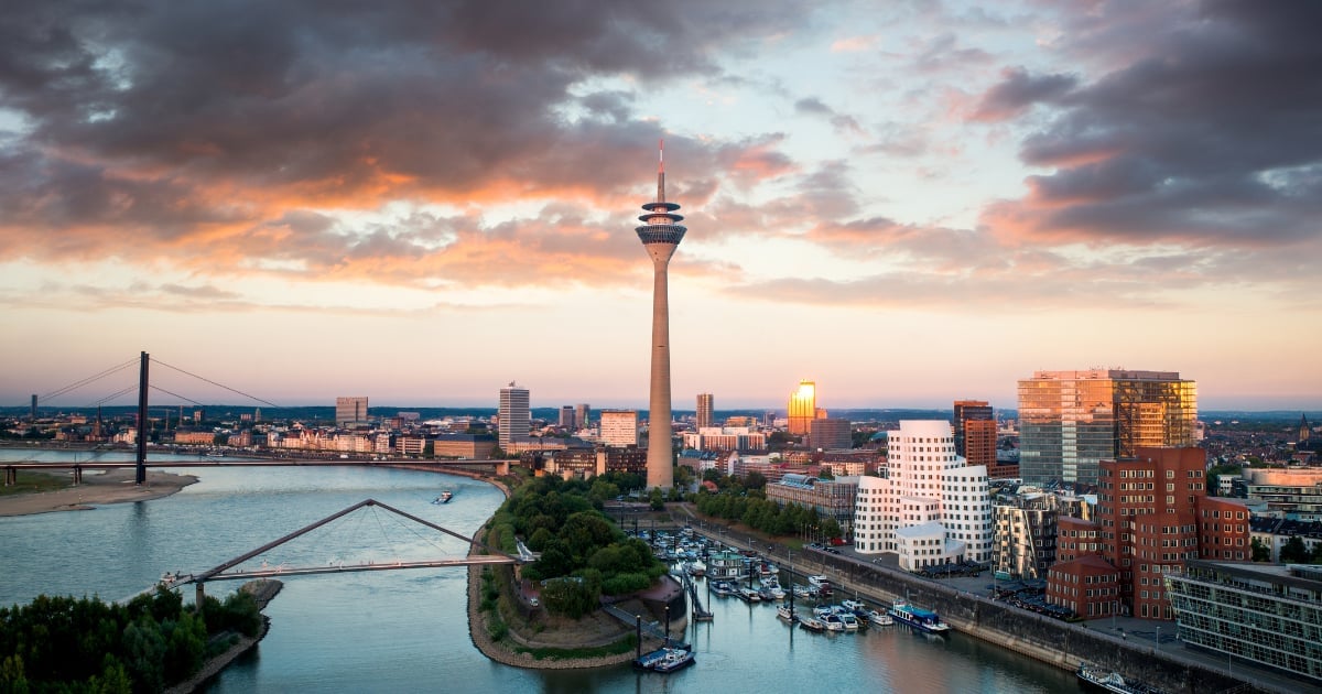Aerial view of Dusseldorf skyline at sunset with TV tower, Rhine River, bridges, and colorful sky